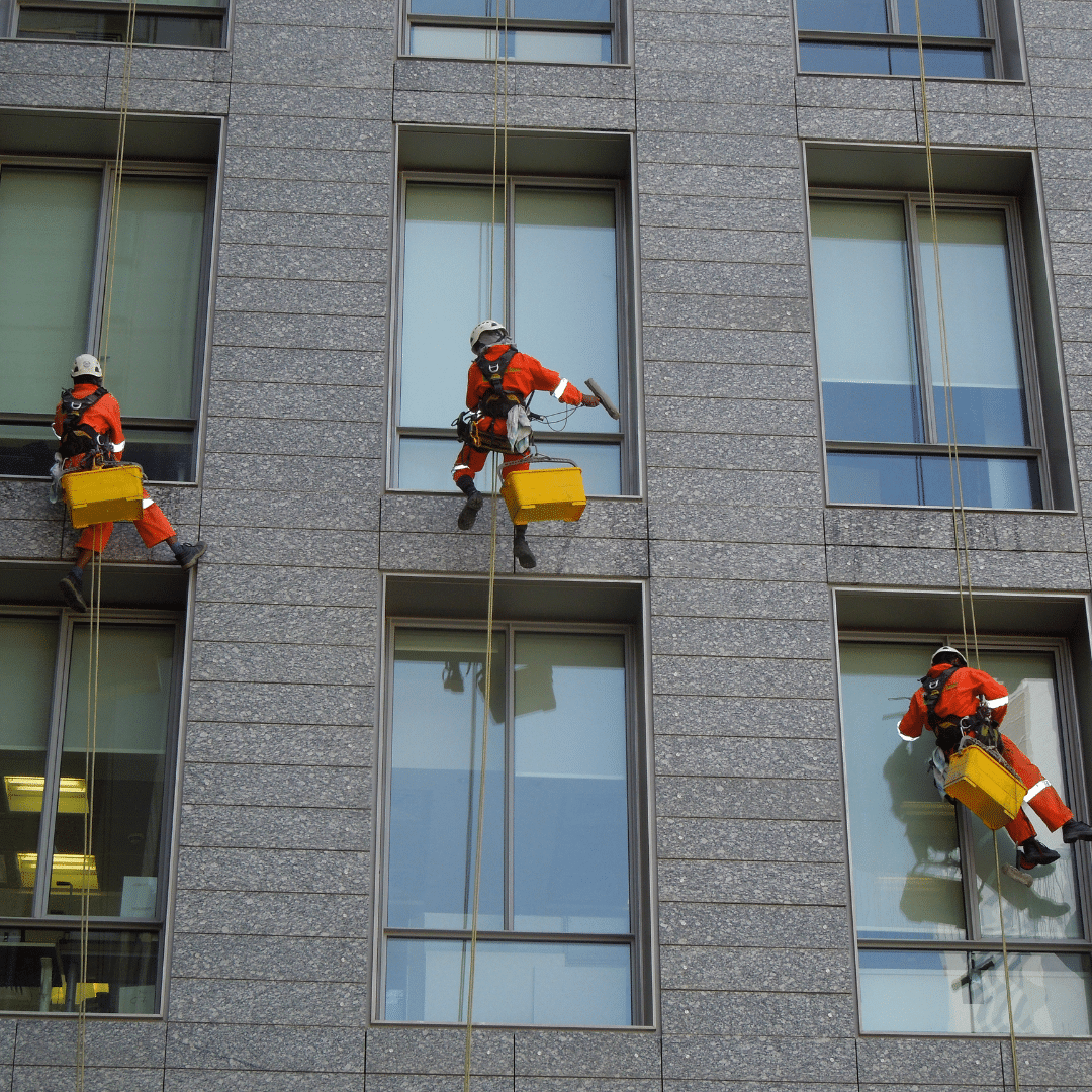Three Severn Access rope access technicians completing window cleaning on a Cardiff high-rise building