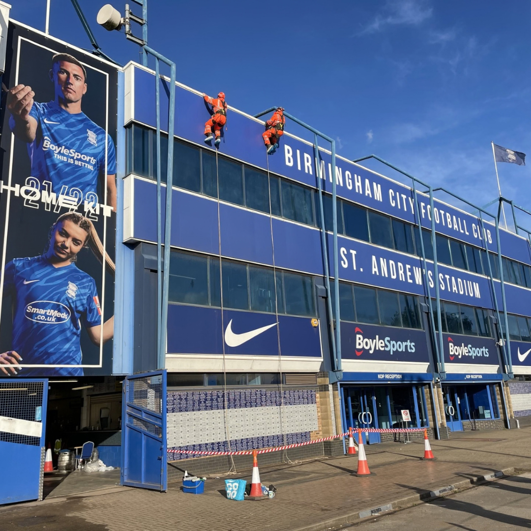 Two Severn Access rope access contractors carrying out Birmingham facade cleaning services at St Andrews @Knighthead Park Stadium