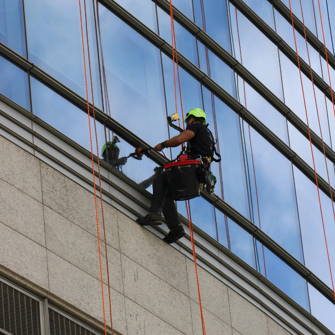 A Severn Access technician performing rope access window cleaning on a high-rise structure